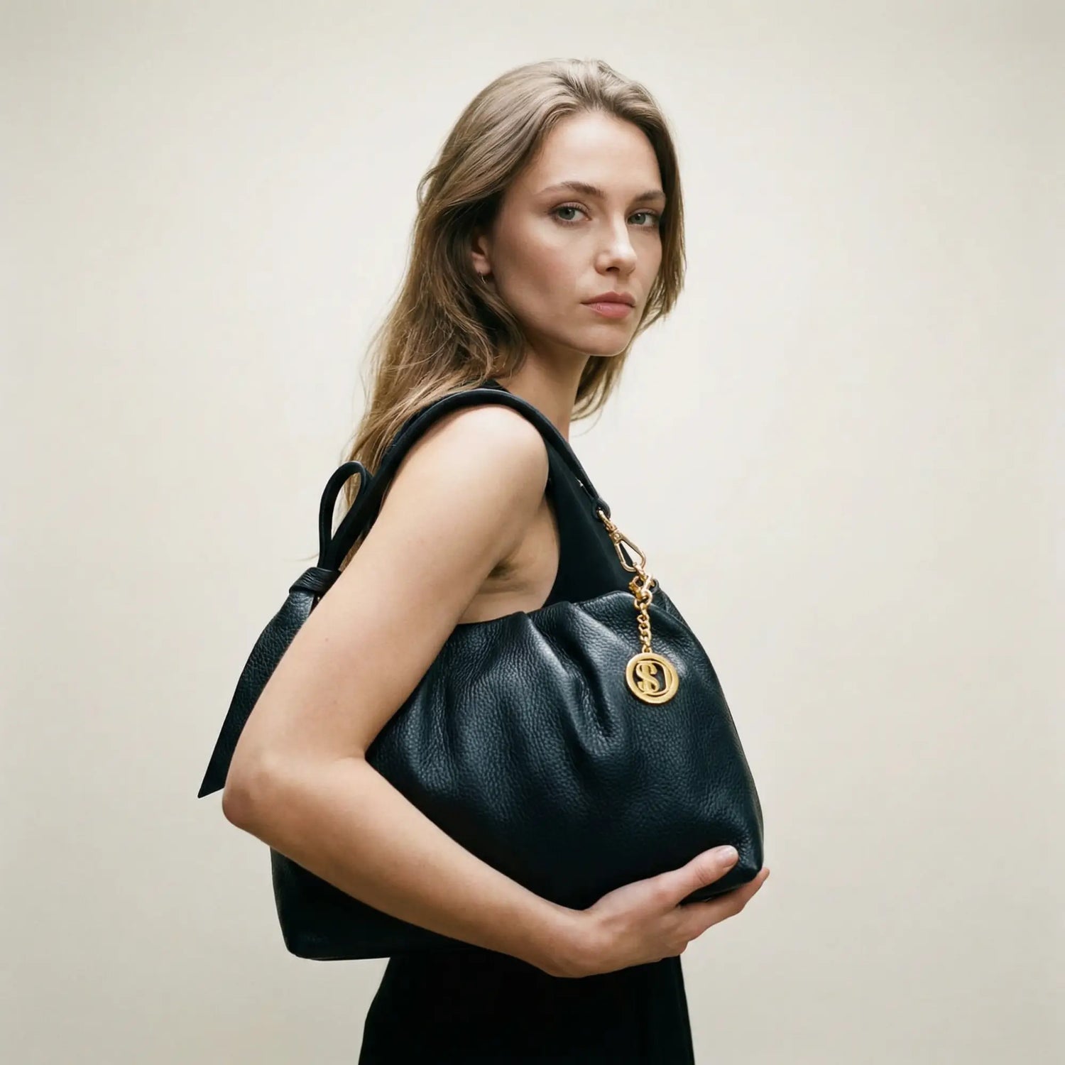 Borsa in suede beige con tracolla in pelle marrone e chiusura oro.